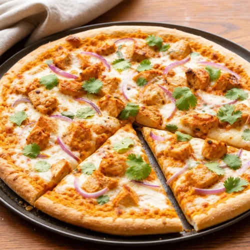 pizza butter chicken maison avec poulet sauce crémeuse oignon rouge et coriandre